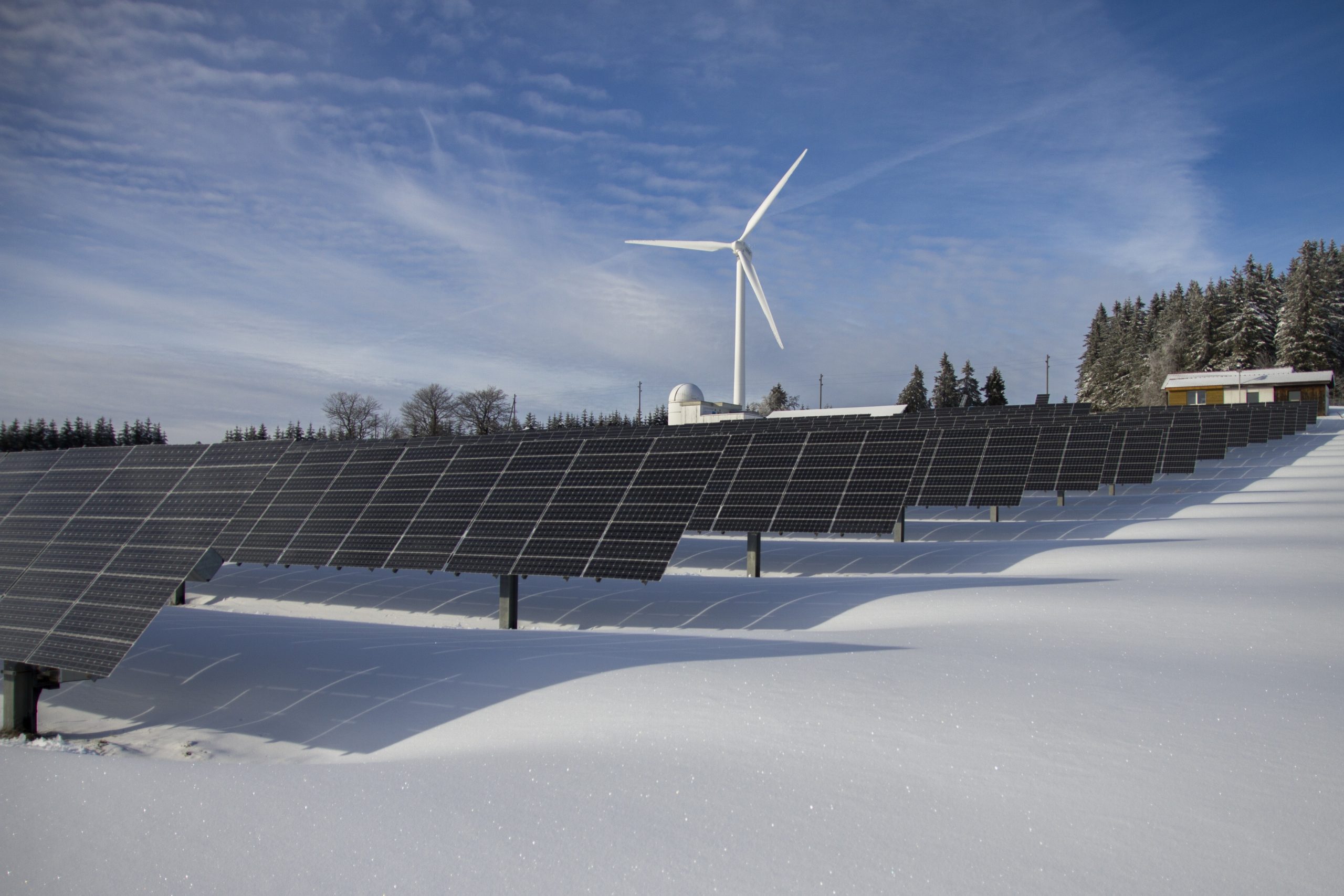 Solar Array with Wind turbine in the snow.