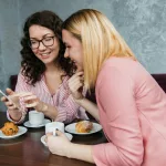 Friends talking a in a coffee shop and eating croissants.